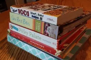 Stack of recipe books for meal planning for frugal living tip